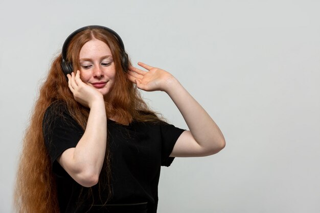 Ingwer Dame, die Musik im schwarzen Kleid auf Grau hört