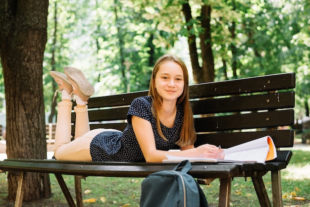 Kostenloses Foto inhalt jugendlich mit studien auf der bank