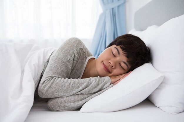 Inhalt Junge asiatische Frau schläft im Bett