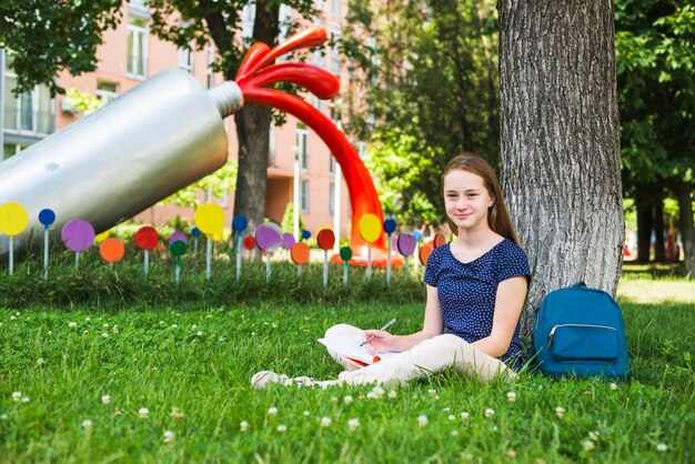 Inhalt Student sitzt auf Gras mit Notizen