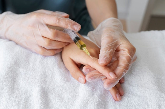 Injizierender Finger des medizinischen Fachpersonals mit niedrigem Winkel