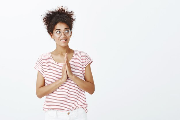 Kostenloses Foto innenaufnahme der bezaubernden frau mit afro-frisur, die im studio aufwirft