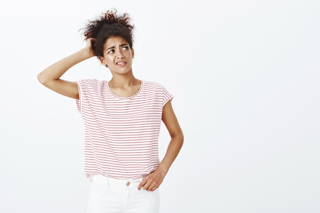 Kostenloses Foto innenaufnahme einer unsicheren frau mit afro-frisur, die im studio aufwirft