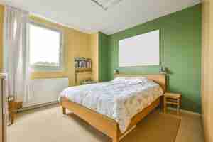Kostenloses Foto innenbild eines schlafzimmers mit einem queen-bett und einer grünen wand