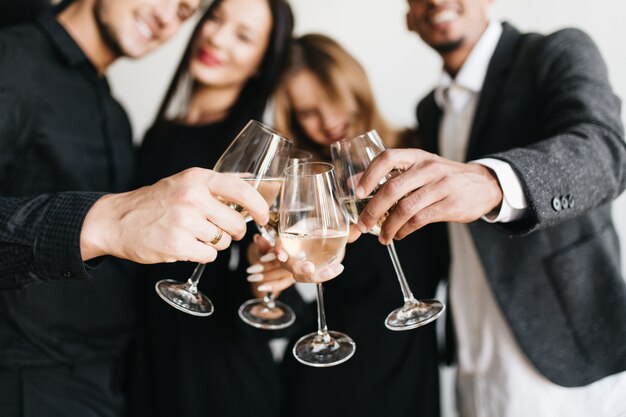 Innenporträt der romantischen blonden Frau, die auf der Party des Freundes kühlt und mit Glas voll Champagner posiert