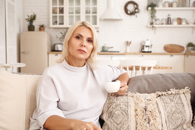 Innenporträt einer Frau, die auf der Couch sitzt