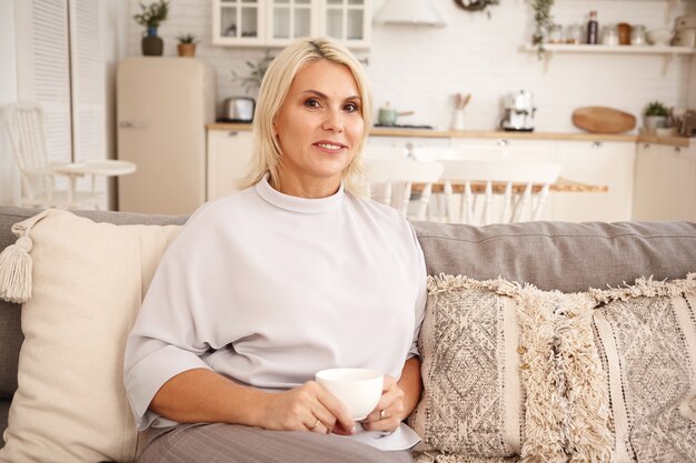 Innenporträt einer Frau, die auf der Couch sitzt