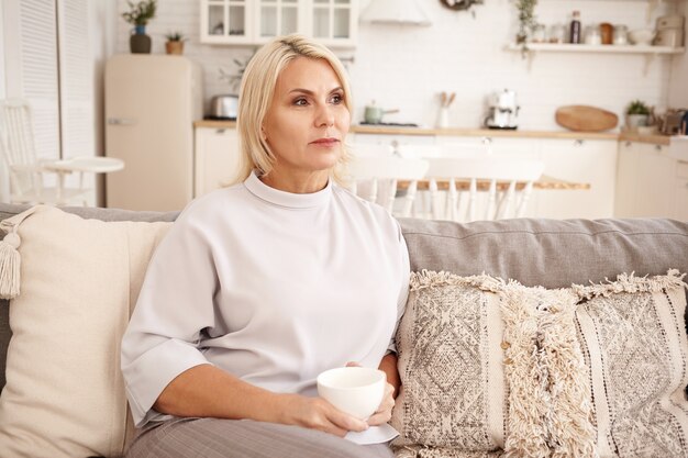 Innenporträt einer Frau, die auf der Couch sitzt