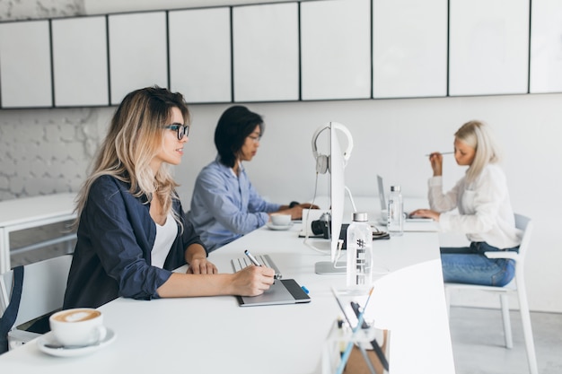 Innenporträt junger Webentwickler internationaler Unternehmen, die eine Kaffeepause einlegen