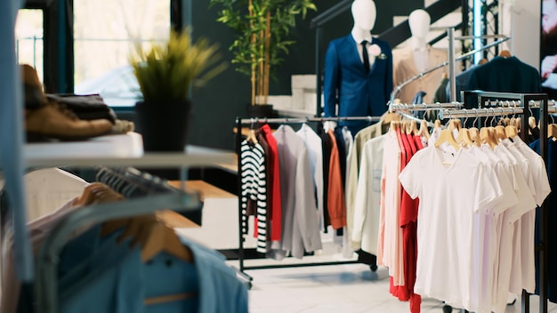 Innenraum eines Bekleidungsgeschäfts mit stilvollen Waren auf Regalen, modischem Markendesign und Freizeitkleidung in einer modernen Boutique. Leerer Modeschauraum im Einkaufszentrum mit eleganten Waren.