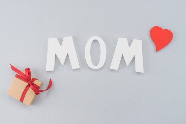 Inschrift Mom mit Geschenkbox und Herz