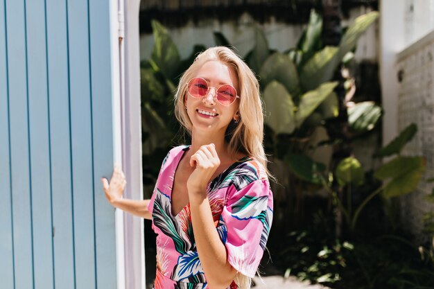 Inspirierte stilvolle Frau in eleganter Kleidung, die im Sommertag herumläuft.