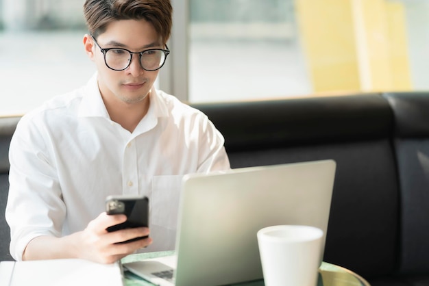 Intelligente, attraktive, positive asiatische Geschäftsmänner, die eine Brille tragen, arbeiten entfernt, neuer normaler Lebensstil, Handgebrauch, Laptop-Telekonferenz, Onlive-Videoanruf, Treffen, entferntes Geschäftsideenkonzept