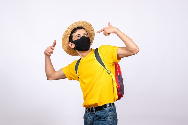 Intelligenter junger Mann der Vorderansicht mit Maske und gelbem T-Shirt, das Finger auf sich selbst zeigt