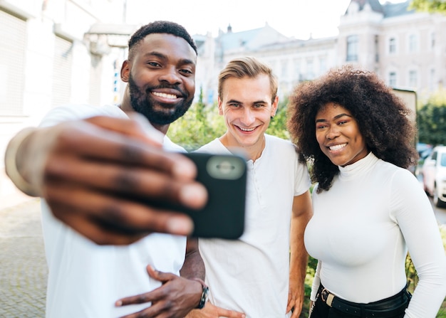 Interkulturelle Freunde des smiley, die selfie nehmen