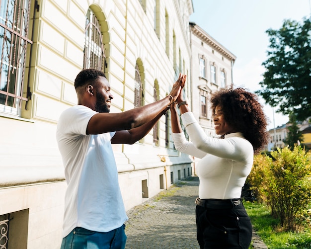 Interkulturelle Freunde klatschen in die Luft