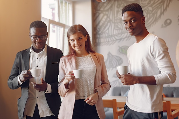 Internationale Leute reden in einem Café und trinken einen Kaffee