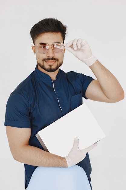 Internationaler Medizinstudent. Mann in blauer Uniform. Doktor mit Spritze.