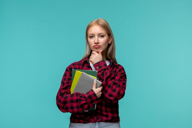 Internationaler Studententag junges süßes Mädchen in rot kariertem Hemd, das mit Büchern in den Händen denkt