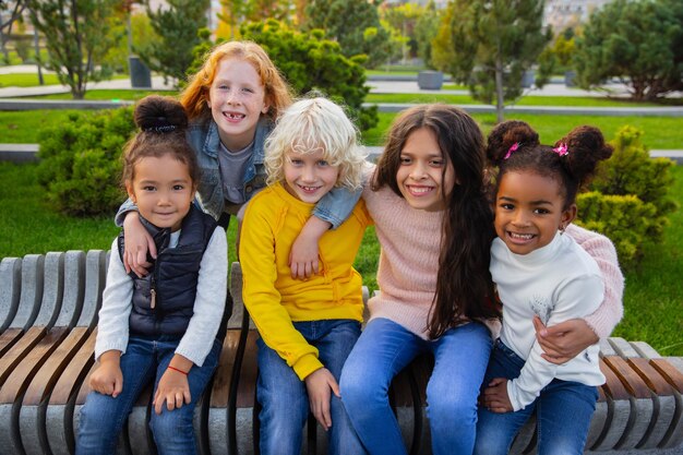 Interracial Gruppe von Kindern, Mädchen und Jungen, die am Sommertag zusammen im Park spielen