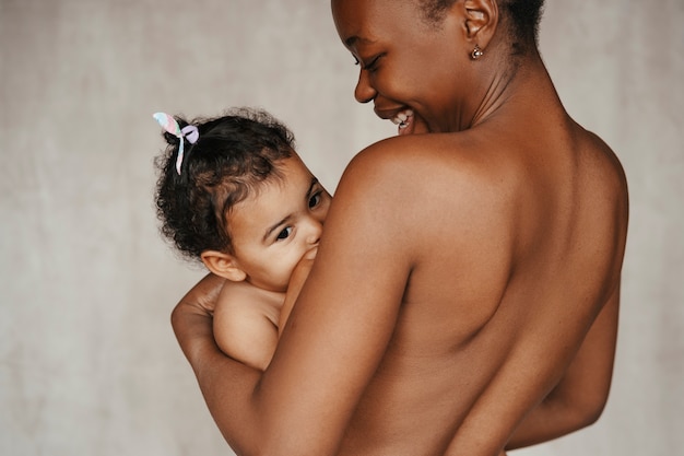 Kostenloses Foto intimes porträt einer schönen mutter, die ihr baby hält