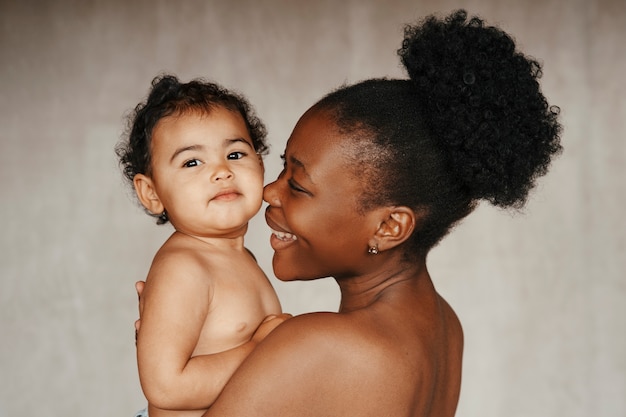 Intimes Porträt einer schönen Mutter, die ihr Baby hält