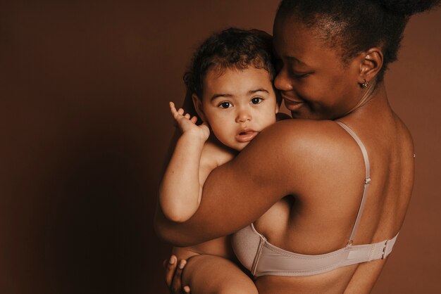 Intimes Porträt einer schönen Mutter, die ihr Baby hält