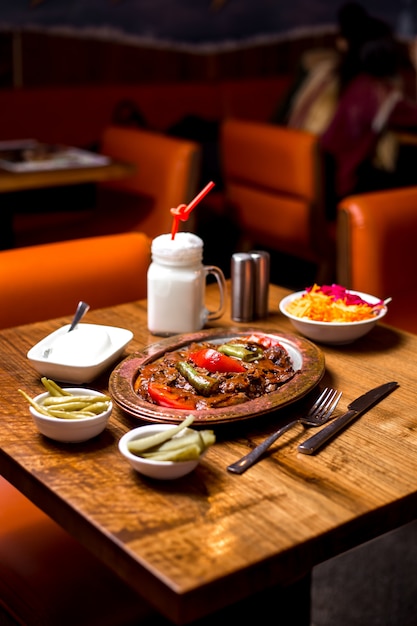 Iskender kebab in kupfer portion serviert mit gurken joghurt und ayran