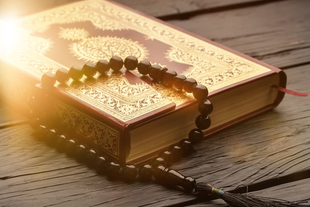 Islamisches buch koran mit rosenkranz im hintergrund