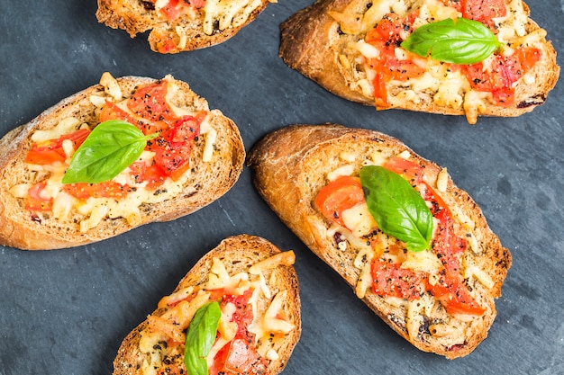 Italienische bruschetta mit gebratenen tomaten, mozzarella-käse und ...