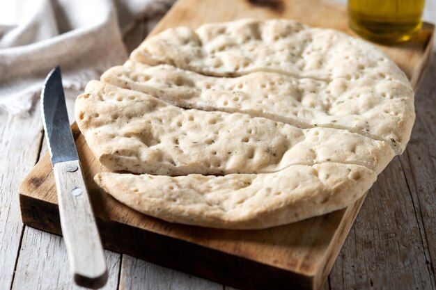 Italienische Focaccia mit Rosmarin auf Holztisch xA