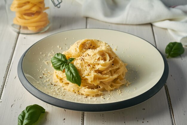 Italienische pasta fettuccine alfredo mit butter-parmesan-käse auf weißem hintergrund