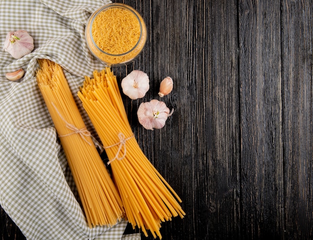 Italienische Pasta Linguini Spaghetti Knoblauch auf dem dunklen hölzernen Hintergrund Draufsicht kopieren Raum