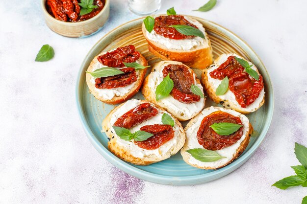 Italienische Sandwiches - Bruschetta mit Käse, trockenen Tomaten und Basilikum.