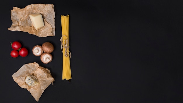 Kostenloses Foto italienischer spaghettiteigwarenbestandteil mit kopienraum auf schwarzer oberfläche