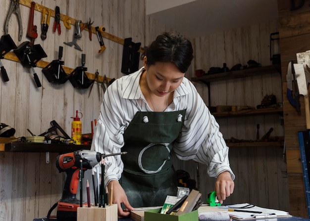 Japanische Frau des mittleren Schusses, die Holz misst