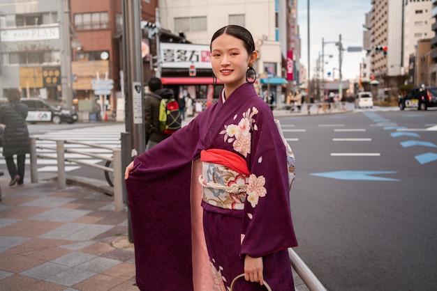 Kostenloses Foto japanische frau, die den tag des erwachsenwerdens feiert und in der stadt posiert