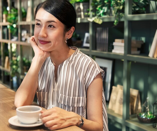 Japanische Frau, die einen Kaffee trinkt