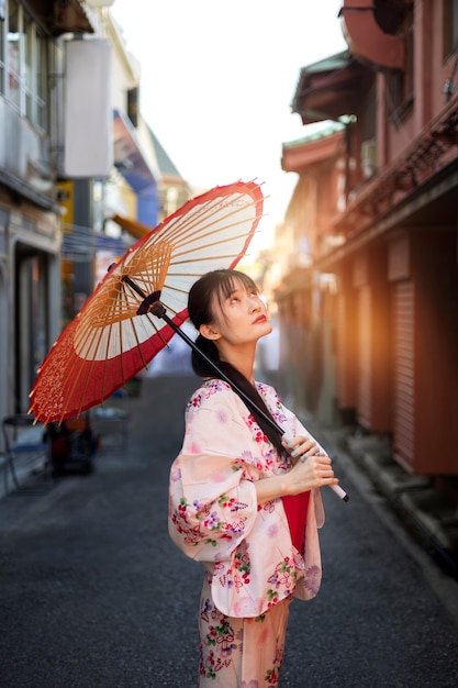 Kostenloses Foto japanische wagasa-regenschirmhilfe durch junge frau