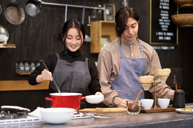 Japanischer Mann und Frau, die in einem Restaurant kochen