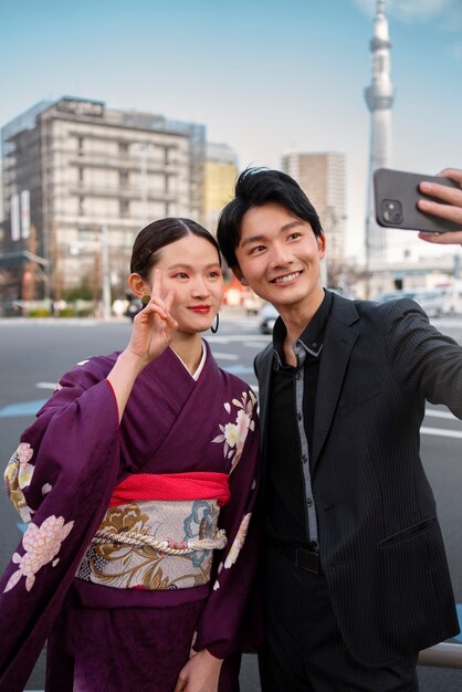 Japanisches Paar feiert den Tag der Volljährigkeit im Freien mit einem Selfie