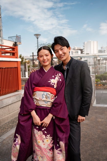 Kostenloses Foto japanisches paar posiert im freien und feiert den tag der volljährigkeit