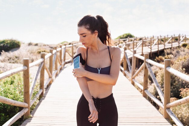 Jogger Frau mit Smartphone am Arm