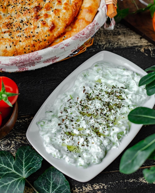 Kostenloses Foto joghurt-kräuter-dressing mit gewürzen und tandir-brot.