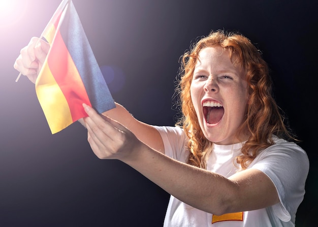 Jubelnde Frau, die deutsche Flagge hält