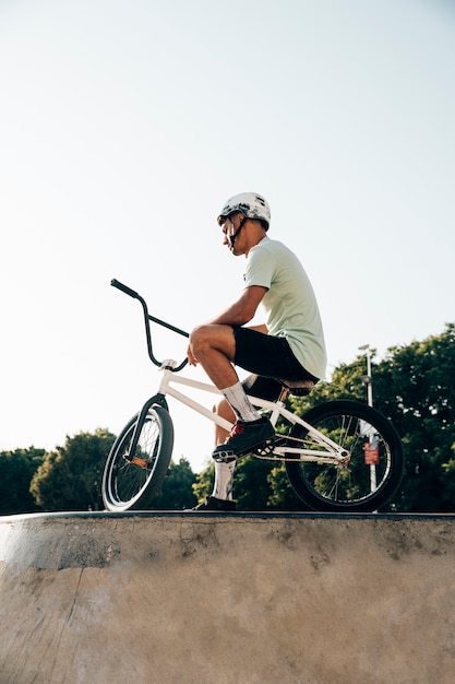 Jugend-bmx Mitfahrer, der mit seiner niedrigen Winkelsicht des Fahrrades steht