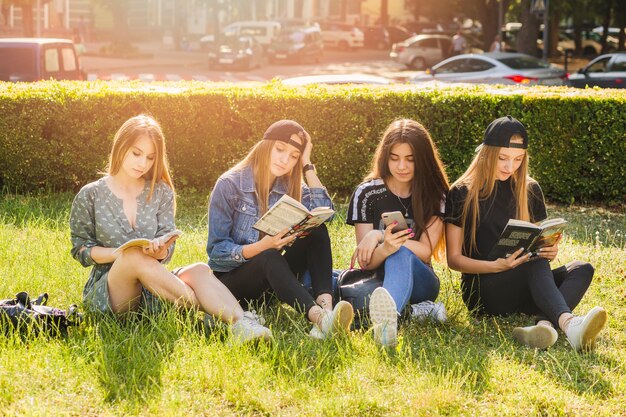 Jugendlich Mädchen, die Bücher lesen und Smartphone verwenden