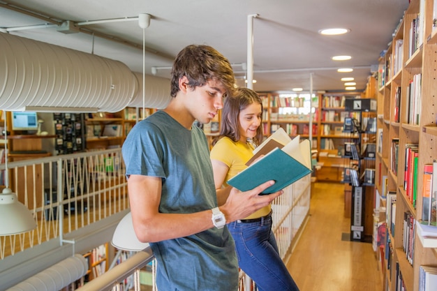 Jugendlich Paare, die das Lesen nahe Geländer genießen