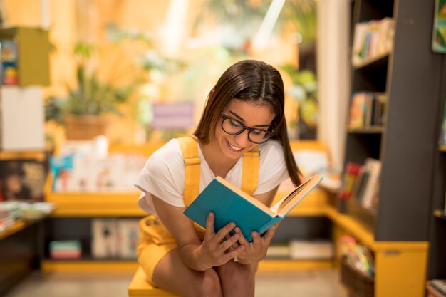 Jugendlich Schulmädchen, das fasziniertes Buch liest