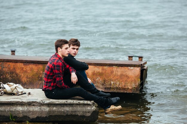 Jugendliche auf dem Pier sitzt